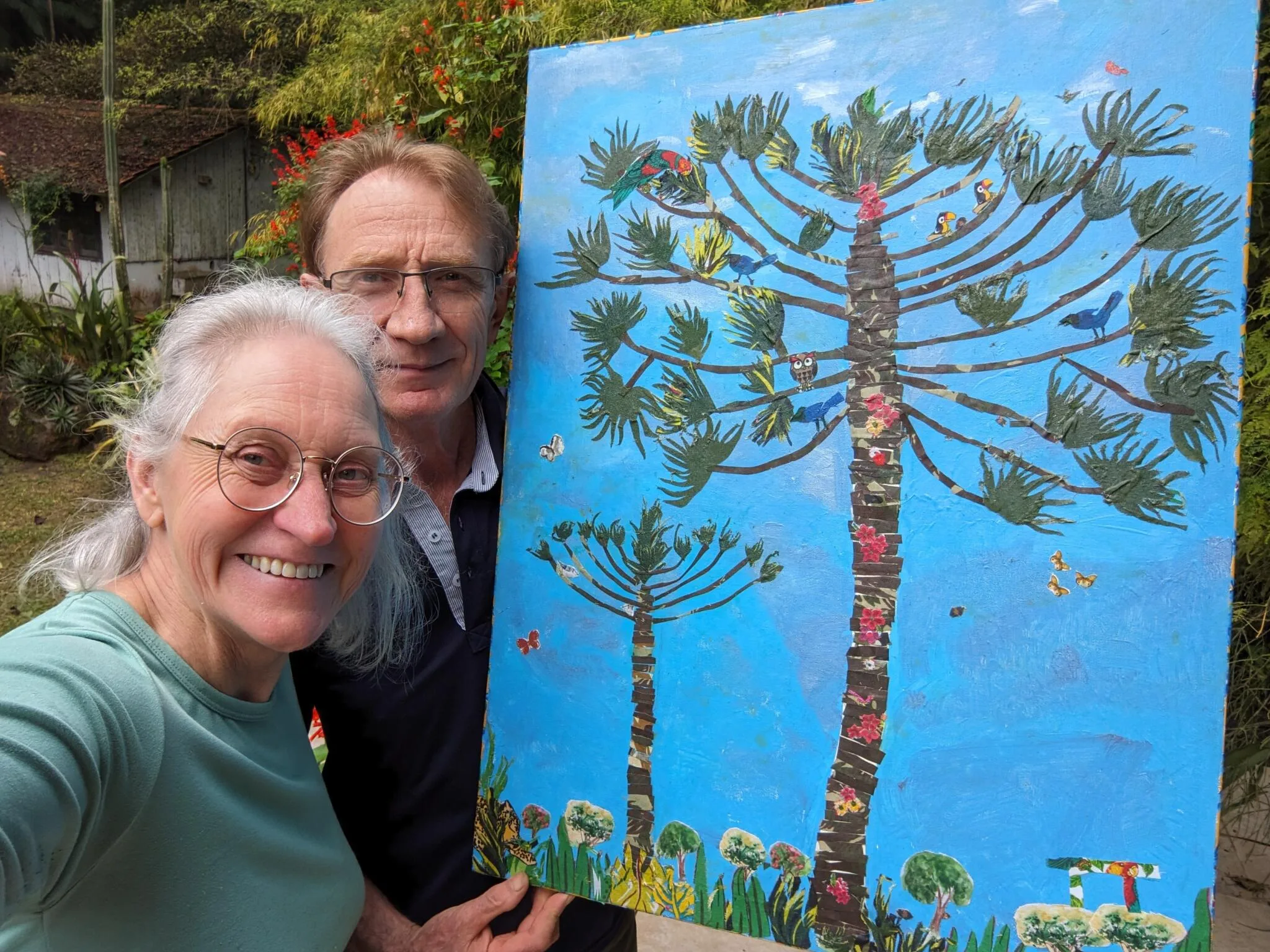 Miriam e Wigold com a obra “Minha Primeira Araucária” por Tetê Brandolim, 2023