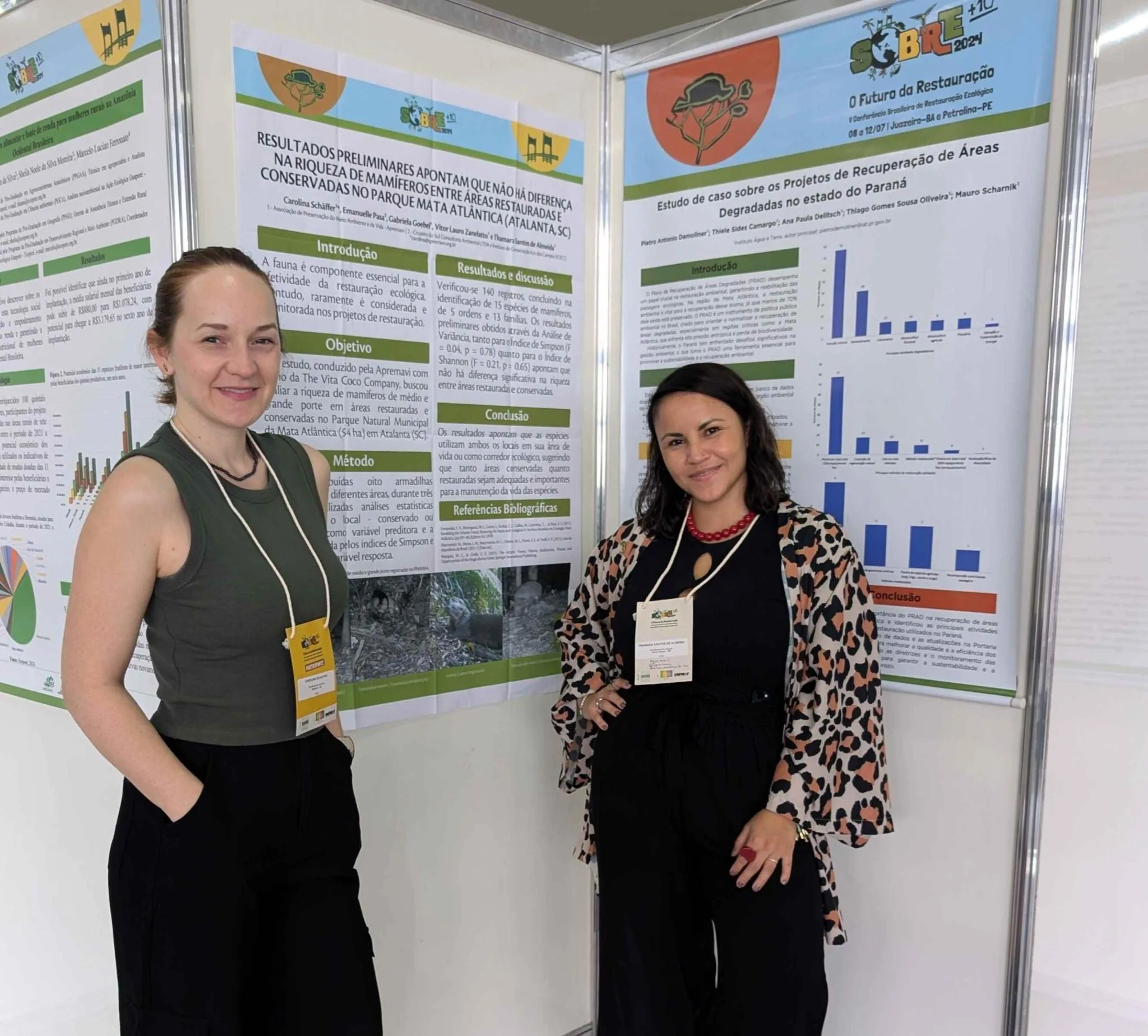 Thamara Almeida e Carolina Schaffer da Apremavi no café com pôster da V Conferência Brasileira de Restauração.